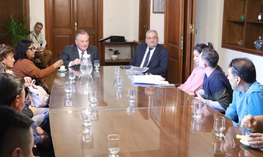 Senadores Felipe Michlig y Alcides Calvo reunidos con trabajadores de la empresa Láctea Verónica en la Sala de Reuniones del Senado.
